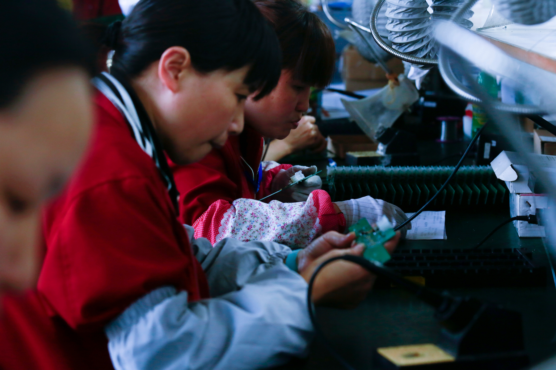 A female factory worker handles a circuit board